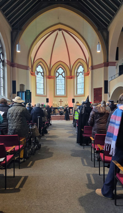 Kirchraum mit Gottesdienstbesuchern von hinten