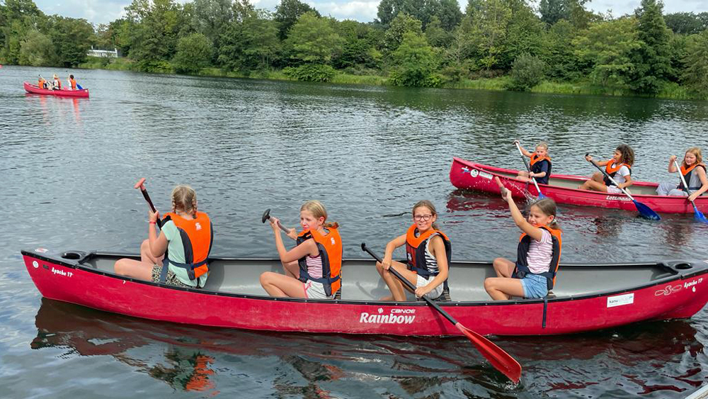 Kinder in Kanus auf dem Wasser
