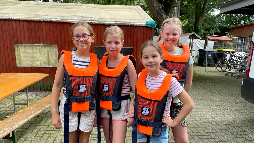 Vier Kinder mit Schwimmwesten