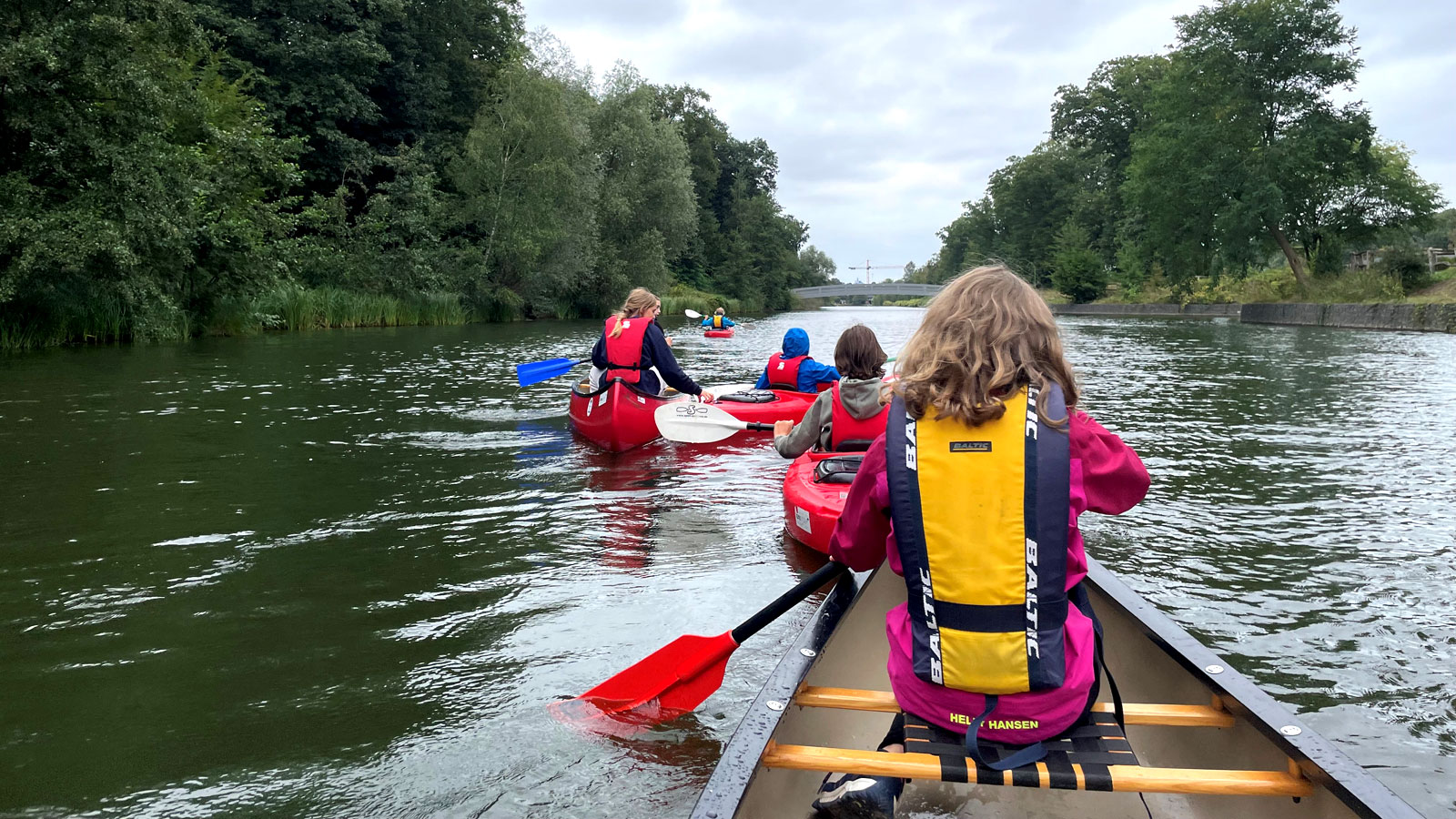 Kinder in Kanus auf einem Fluss