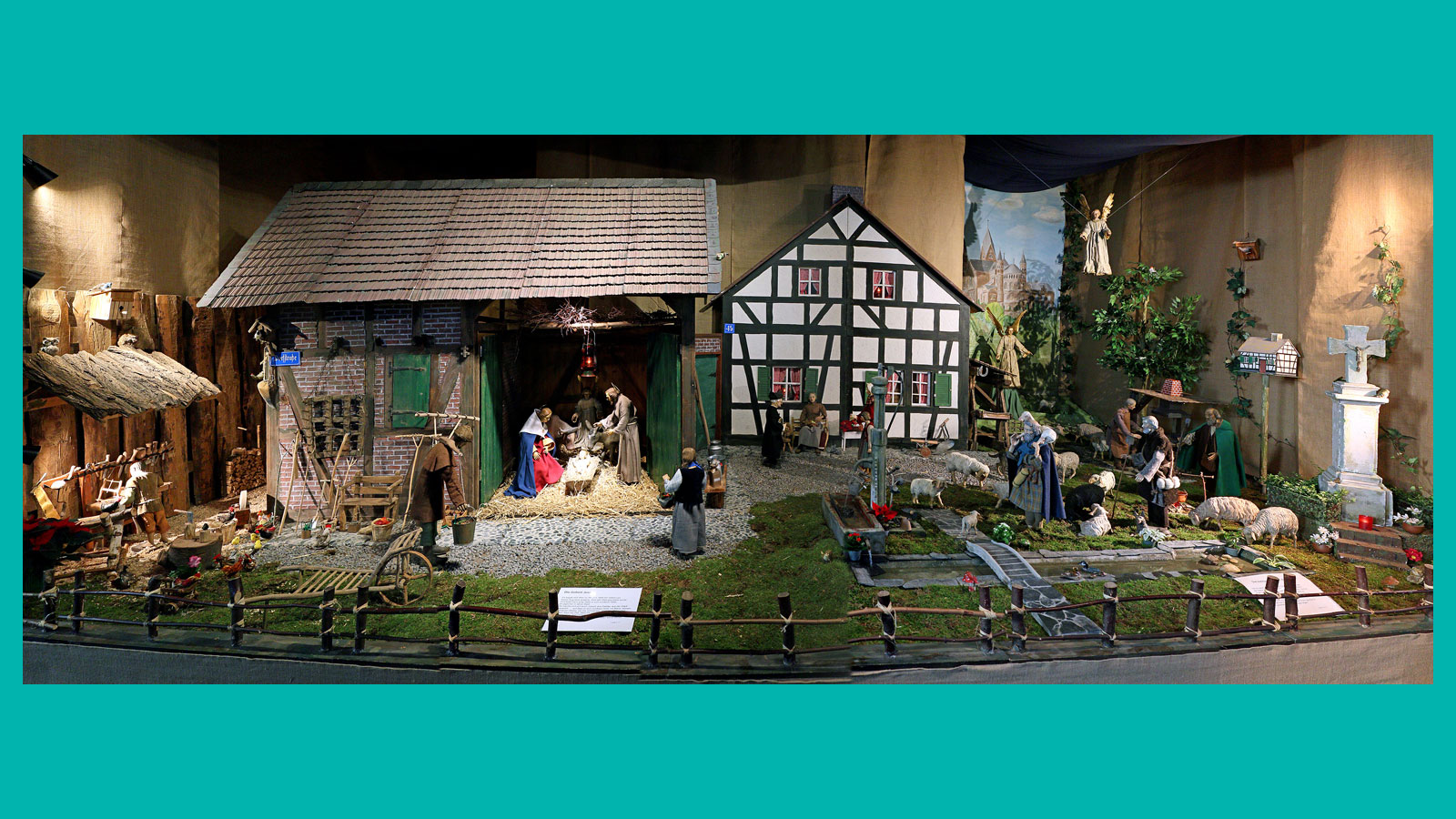 Detail aus der Krippenlandschaft: Schreinerwerkstatt, Scheune mit Hl. Familie, Wohnhaus aus Fachwerk, Bachlauf und Br&uuml;cke, weitere Figuren