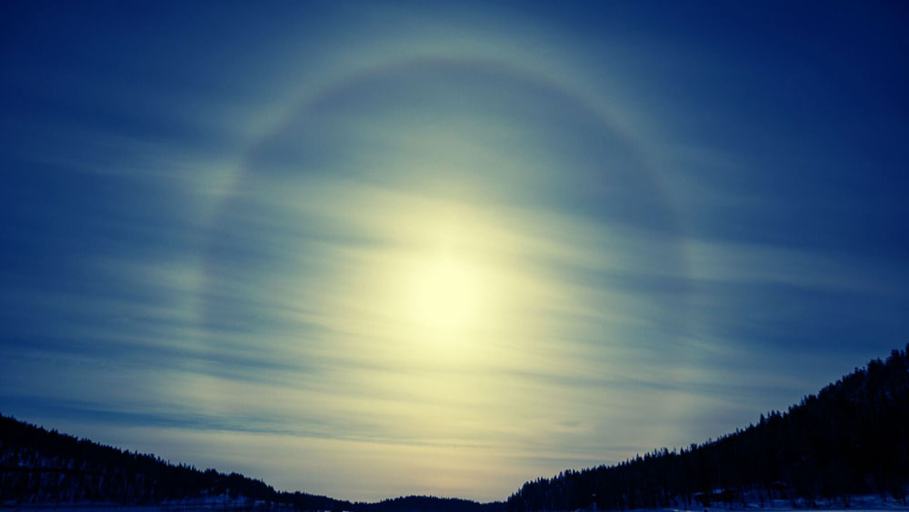 Sonnenuntergang über zugefrorerem See, in Blautönen verfremdet