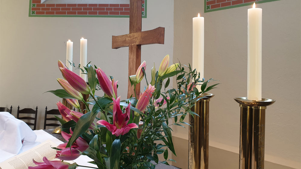 Altar der Mutterhauskirche miz Kreuz, Kerzen und Blumenstrau&szlig;
